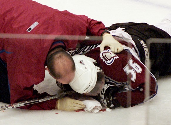 Colorado Avalanche forward Steve Moore is attended to by the team trainer after being injured in a fight with Vancouver Canucks Todd Bertuzzi during the third period of NHL action in Vancouver, Britis ...