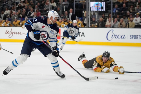 Winnipeg Jets right wing Nino Niederreiter (62) passes around Vegas Golden Knights right wing Mitch Marner (93) during the third period of an NHL hockey game Monday, April 13, 2026, in Las Vegas. (AP  ...