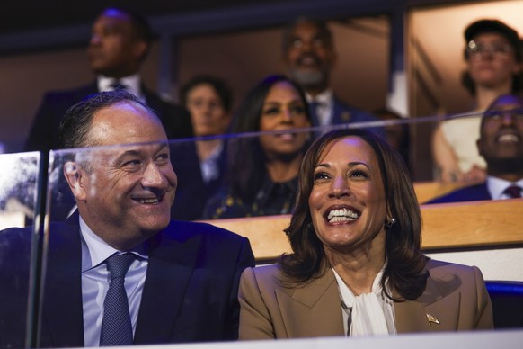 Second gentleman Doug Emhoff, left, and Democratic presidential nominee Vice President Kamala Harris listen during speeches at the Democratic National Convention, Monday, Aug. 19, 2024, in Chicago. (G ...