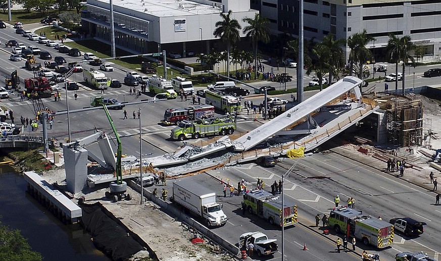 Emergency personnel respond after a brand-new pedestrian bridge collapsed onto a highway at Florida International University in Miami on Thursday, March 15, 2018. The pedestrian bridge collapsed onto  ...