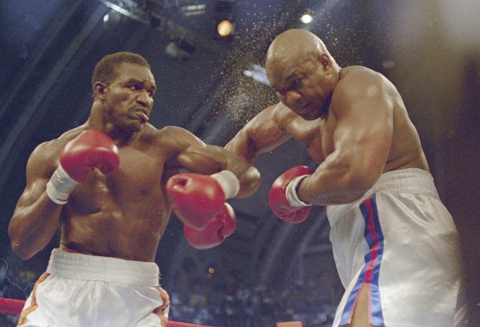 Heavyweight champion Evander Holyfield, left, lands a punch on George Foreman in their 12-round bout, April 19, 1991, in Convention Hall, Atlantic City, New Jersey. (AP Photo)