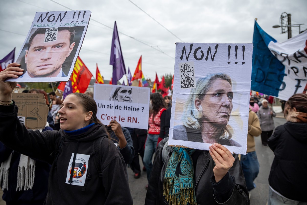 epaselect epa13327678 Protesters hold a caricature of Jordan Bardella (L) and Marine Le Pen (R) during a demonstration against racism, fascism and imperialism on the sidelines of the congress of the f ...
