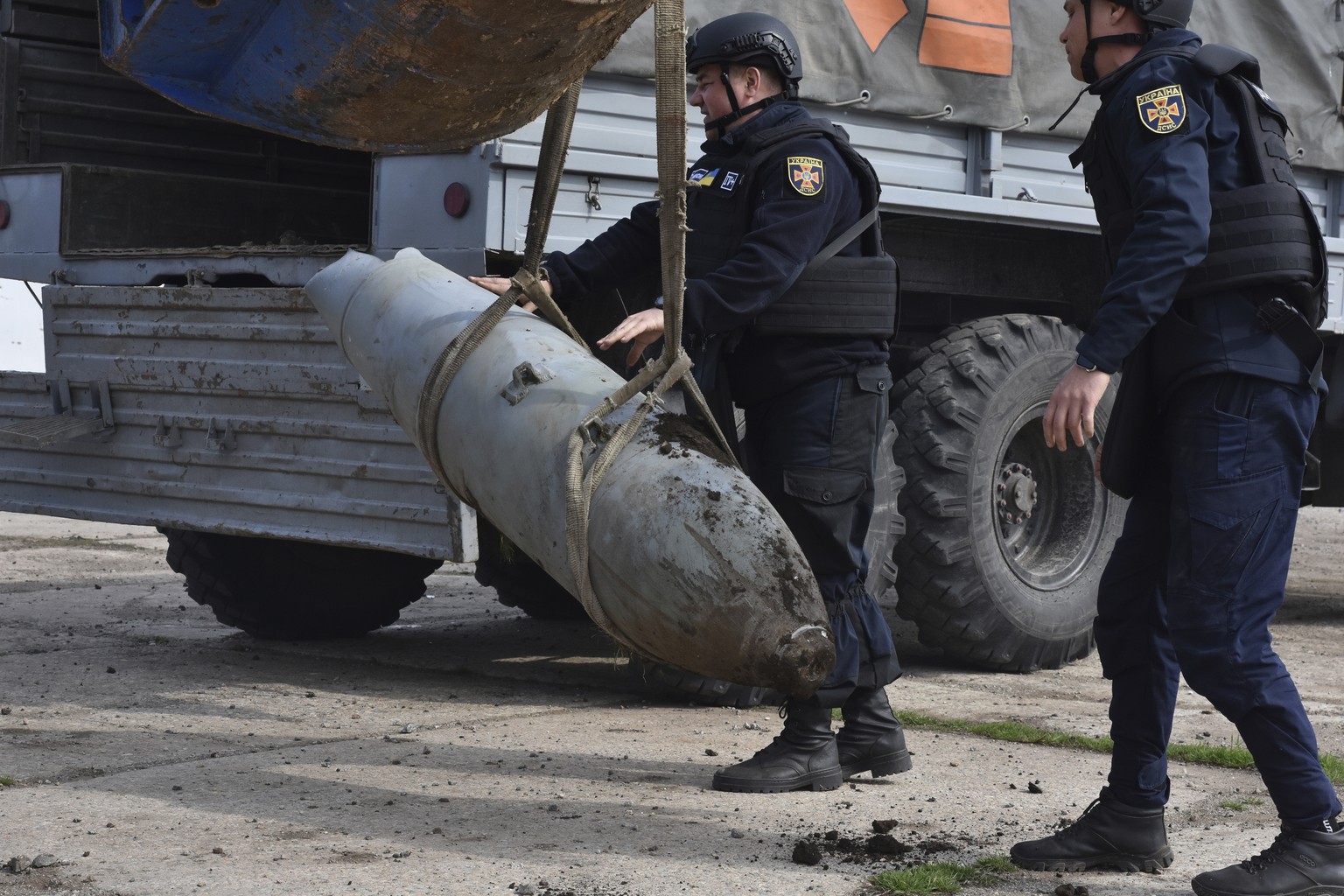 Emergency workers remove a FAB-500 unexploded Russian air bomb in the town of Preobrazhenka, Zaporizhzhia region, Ukraine, Thursday, March 23, 2023. (AP Photo/Andriy Andriyenko)