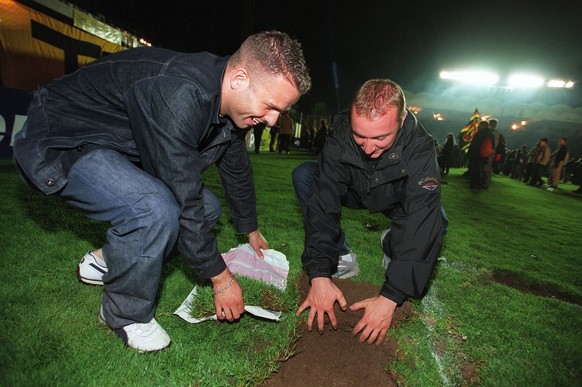 Soccer fans dig up pieces of the lawn of the Wankdorf-Stadium as souvenirs after the stadium's last game between the Bern Young Boys and the FC Lugano, Saturday July 7, 2001 in Bern, Switzerland. ...