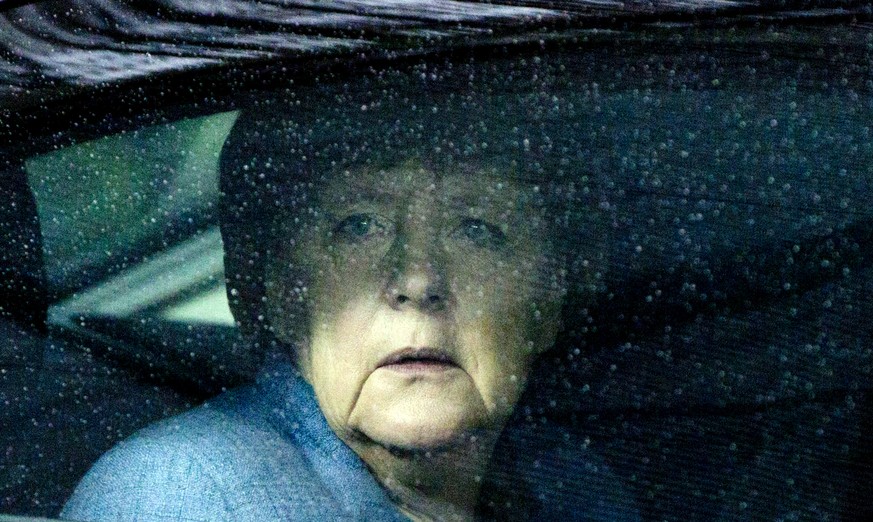 German Chancellor Angela Merkel looks through raindrops on her car window as she arrives for an Eastern Partnership Summit in Brussels, Friday, Nov. 24, 2017. European Union leaders meet with their co ...