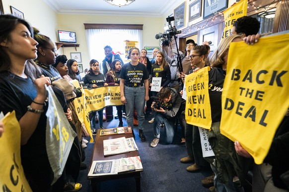 epa07222247 Supporters of Representative elect Ocasio-Cortez&#039;s proposed Select Committee on a &#039;green New Deal&#039; rally inside the office of Democratic Congressman from Maryland and House  ...