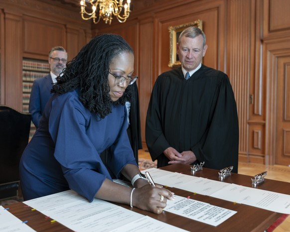 In this image provided by the Collection of the Supreme Court of the United States, Supreme Court Justice Ketanji Brown Jackson signs the Oaths of Office at the Supreme Court in Washington, Thursday,  ...