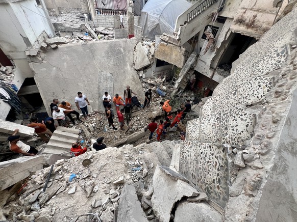 epa11634734 Search and rescue team members try to find victims following an overnight raid by the Israel army on the Palestinian camp of Ain Al Hilweh, in Sidon, Lebanon, 01 October 2024. On 30 Septem ...