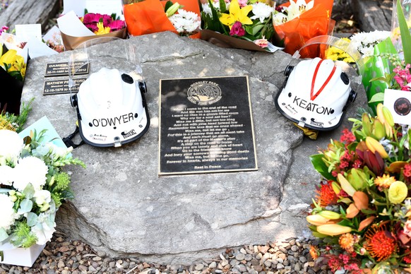 epa08082743 Flowers and the helmets of volunteer firefighters Andrew O&#039;Dwyer and Geoffrey Keaton rest at a memorial at the Horsley Park Rural Fire Brigade in Horsley Park, New South Wales, Austra ...