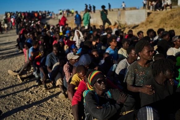 Migrants who crossed from Morocco into Spain line up for food distribution on a beach in the Spanish enclave of Ceuta, Monday, Aug. 3, 2026. (AP Photo/Bernat Armangue)
Migration Spain Ceuta