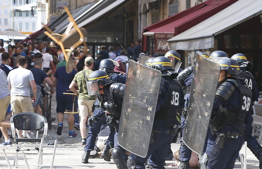 French police officers charge soccer supporters during clashes in downtown Marseille, France, Saturday, June 11, 2016. Riot police have thrown tear gas canisters at soccer fans Saturday in Marseille&# ...