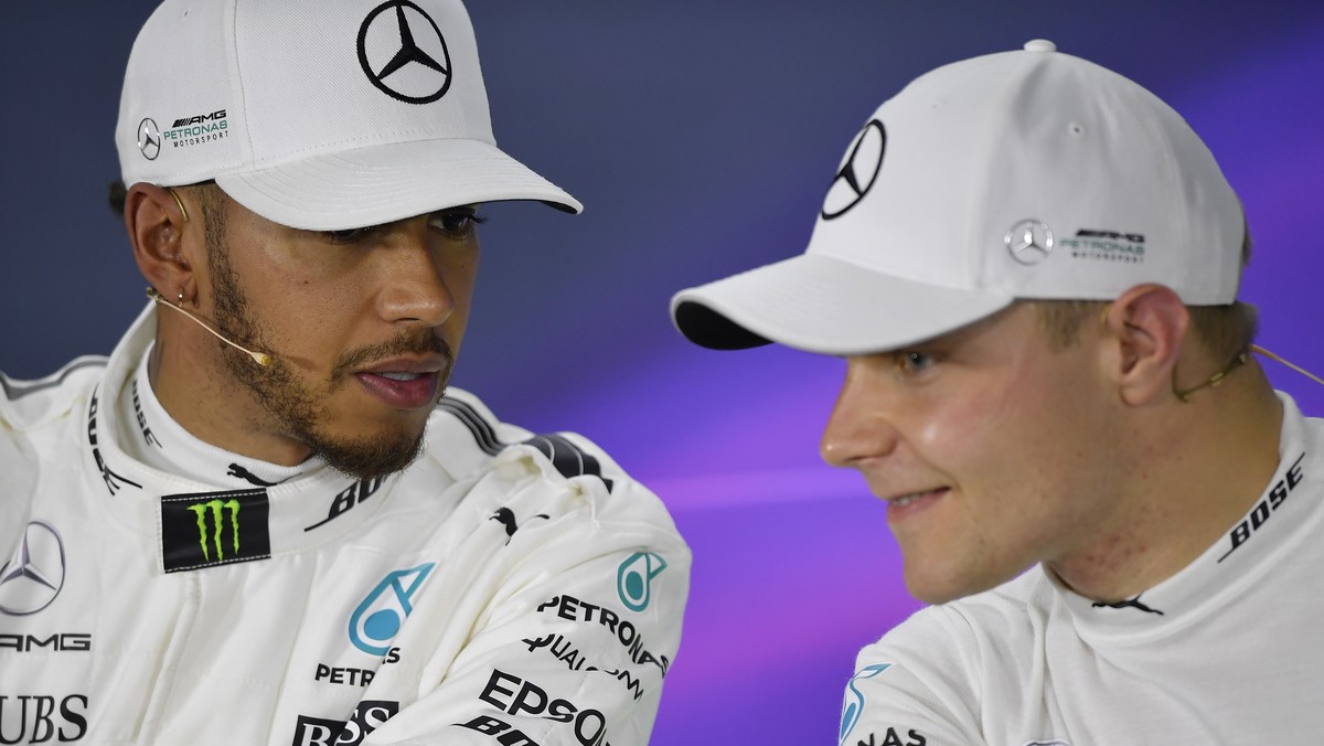 Mercedes driver Lewis Hamilton, left, of Britain talks with teammate Valtteri Bottas of Finland at a press conference after winning qualifying for the Australian Formula One Grand Prix in Melbourne, A ...