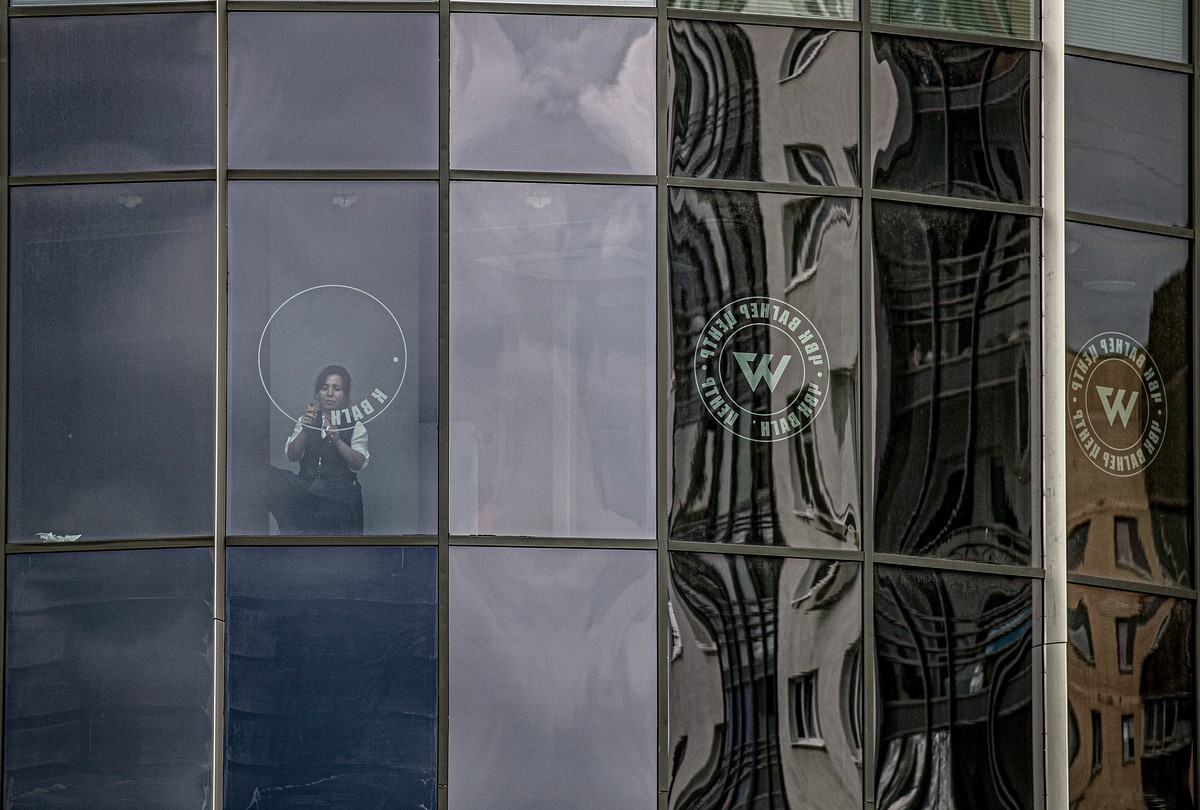 epa10722701 A worker removes the logo of the private military company (PMC) Wagner Group from the windows of the Sea Capital (Morskaya Stolitsa) business center, where Yevgeny Prigozhin's company ...