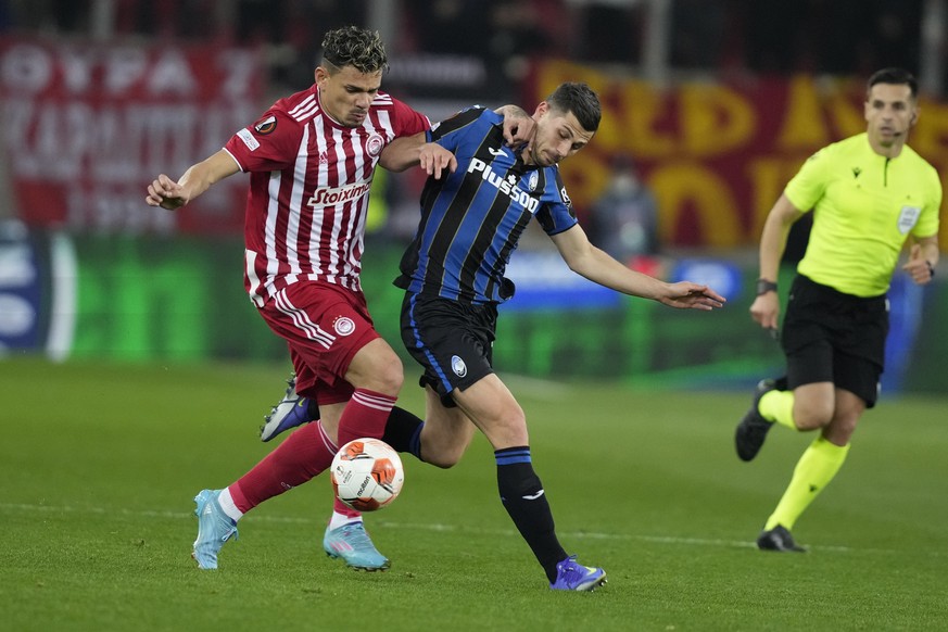 Olympiacos&#039; Tiquinho, left, and Atalanta&#039;s Remo Freuler fight for the ball during the Europa League, round of 32, soccer match between Olympiacos and Atalanta at Georgios Karaiskakis stadium ...