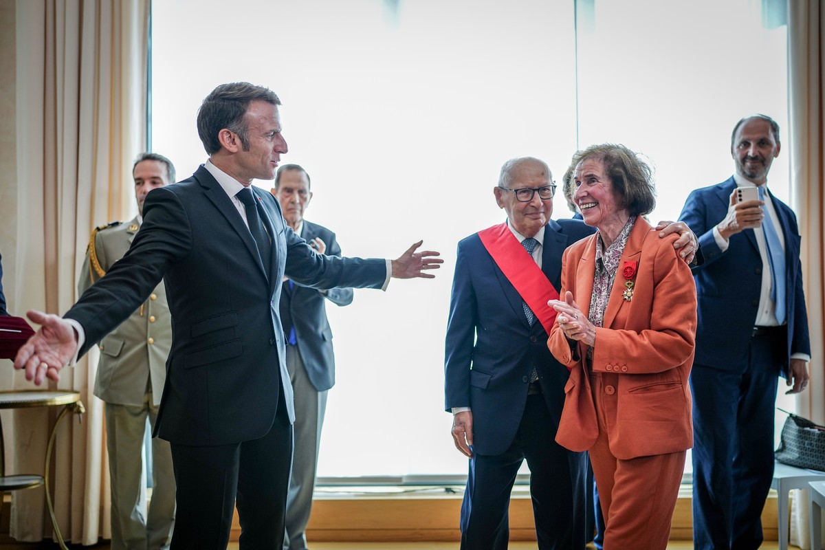 epa11373160 French President Emmanuel Macron (L) gestures after he honored Beate Klarsfeld (2-R) and Serge Klarsfeld (3-R) with the highest French Order of Merit at the French Embassy in Berlin, Germa ...
