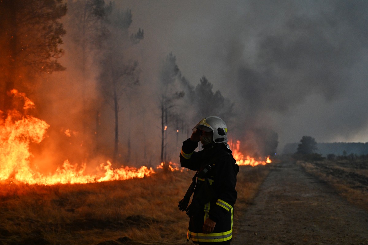 A firefighter gestures next to burning trees as a wildfire rages near Marcheprime, outside, Bordeaux, France, Sunday, July 26, 2026. (AP Photo/Emma Da Silva)
France Wildfires