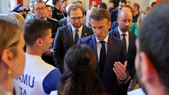epa10681467 French President Emmanuel Macron (C) meets rescue forces at the Haute-Savoie prefecture, the day after several children and adults were injured in a knife attack at the Le Paquier park nea ...
