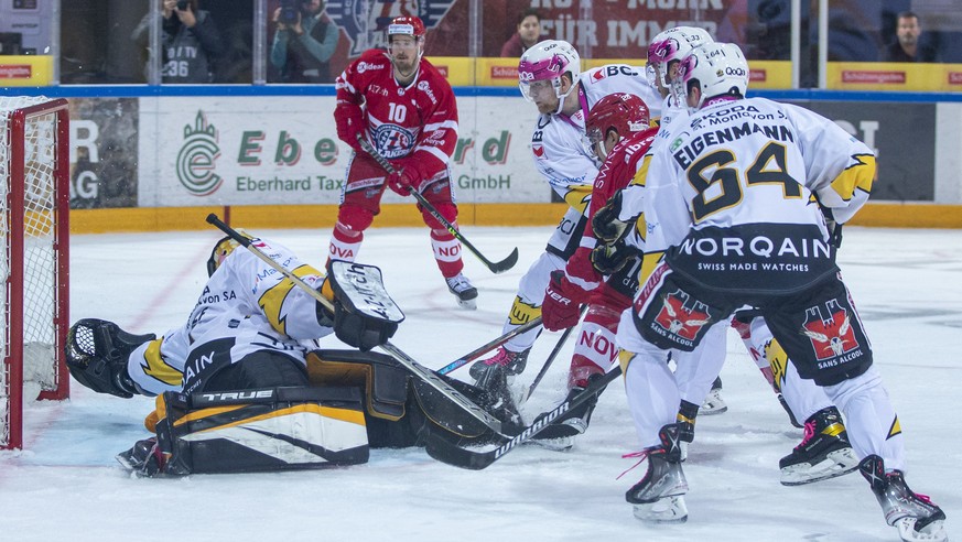 SC Rapperswil-Jona Lakers Stuermer Yannick-Lennart Albrecht, Mitte rechts halb verdeckt, trifft zum 1-0 gegen HC Ajoie Torhueter Tim Wolf, links, waehrend dem Eishockey-Meisterschaftsspiel der Nationa ...