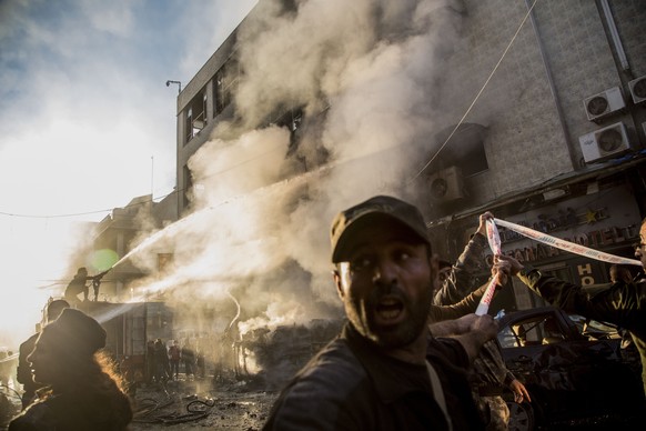 Fireman sprays water after a car bomb blast in the city of Qamishli, northern Syria, Monday, Nov. 11, 2019. Three car bombs went off Monday in then city killing several and wounding tens of people. (A ...