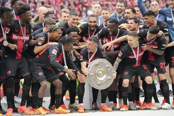Leverkusen&#039;s Granit Xhaka, centre, celebrates with the trophy as his team won the German Bundesliga soccer match between Bayer Leverkusen and FC Augsburg at the BayArena in Leverkusen, Germany, S ...