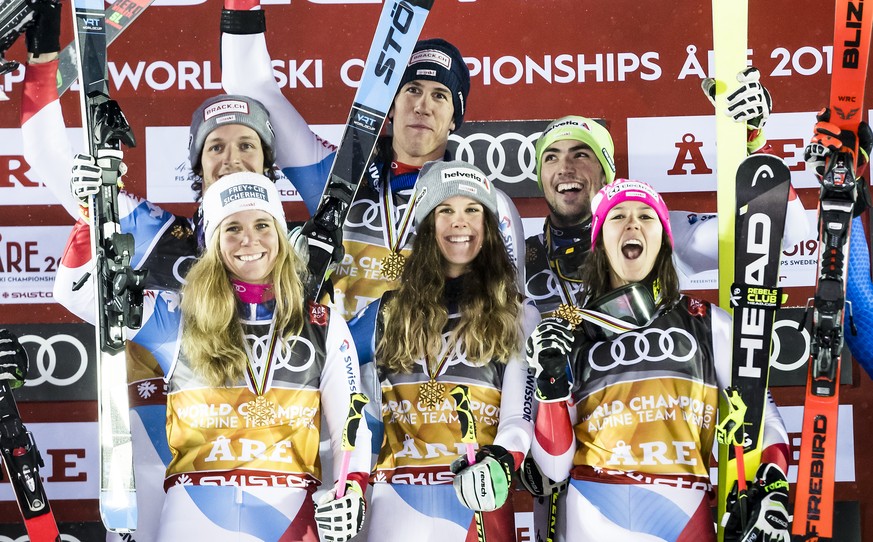 Team of Austria, left, team of Switzerland with Sandro Simonet, Ramon Zenhaeusern, Andrea Ellenberger, Aline Danioth, Wendy Holdener and Daniel Yule, center, team of Italy, right, celebrate during the ...