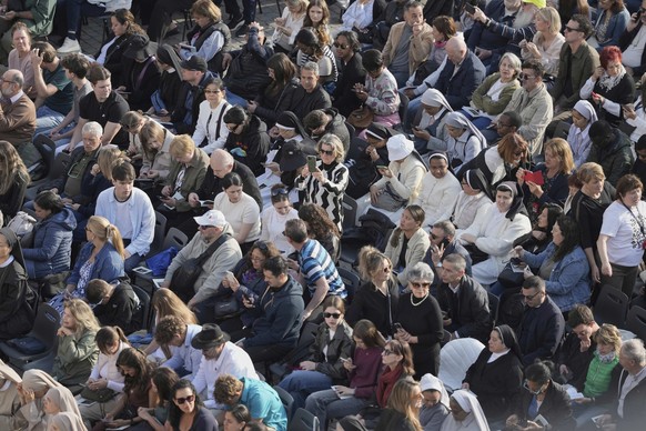 People gather in St. Peter&#039;s Square as they await the arrival of the body of Pope Francis, who will lie in state at St. Peter･s Basilica for three days, at the Vatican, Wednesday, April 23, 2025. ...