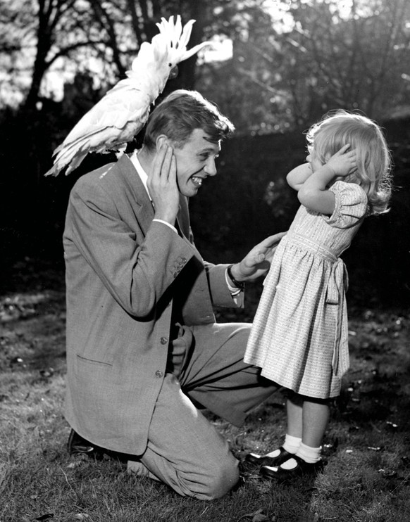 3 year old Susan and her father David Attenborough cover their ears as sulphur crested cockatoo Georgie lets out a piercing shriek. 7th December 1957. 

UnitedArchives 00563834