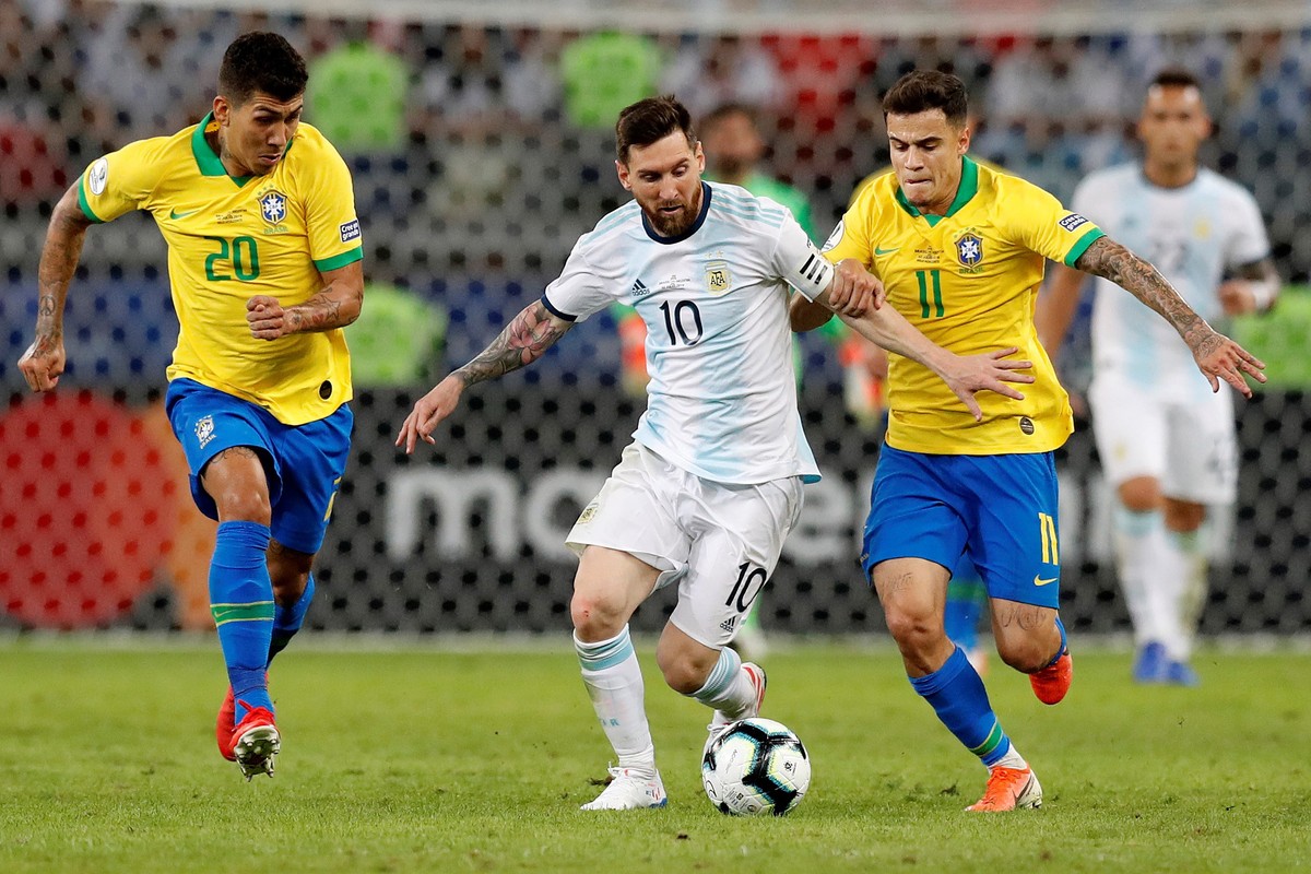 epa07690920 Argentina's Lionel Messi (C) in action against Roberto Firmino (L) and Philippe Coutinho (R) during the Copa America 2019 semi-finals soccer match between Brazil and Argentina at Mine ...