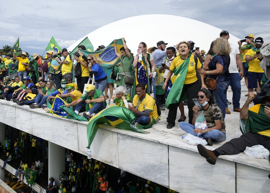 Protesters, supporters of Brazil&#039;s former President Jair Bolsonaro, stand on the roof of the National Congress building after they stormed it, in Brasilia, Brazil, Sunday, Jan. 8, 2023. (AP Photo ...