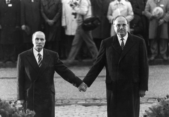 FILE - In this Sep. 22, 1984 file photo, late French President Francois Mitterrand, left, and German Chancellor Helmut Kohl stand hand in hand as they listen to the national anthems during a French-Ge ...