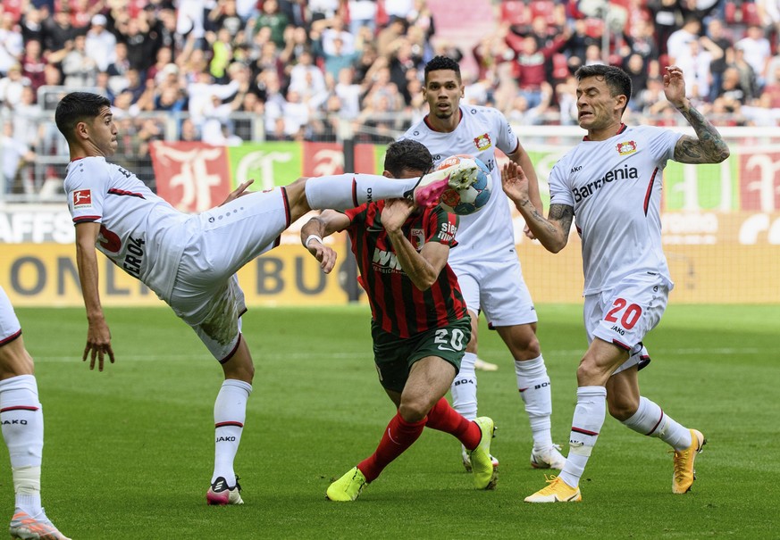 Leverkusen&#039;s Exequiel Palacios, left, Augsburg&#039;s Daniel Caligiuri, center, and Leverkusen&#039;s Charles Aranguiz, right, challenge for the ball during the German Bundesliga soccer match bet ...