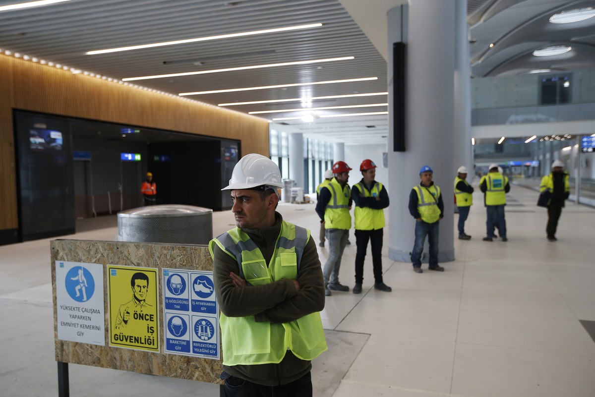 FILE - In this April 13, 2018, file photo, construction workers stand in one of the terminals of Istanbul's third international airport. The first phase of the airport, one of Turkey's Presi ...