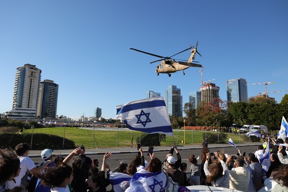 epaselect epa11851573 People watch a military helicopter carrying the four released Israeli female hostages, landing at Rabin Medical Center in Petah Tikva, Israel, 25 January 2025. The four Israeli h ...