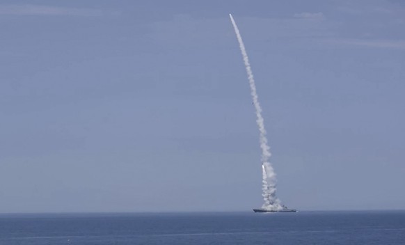 epa10234441 A still image taken from a handout video made available by the Russian Defence Ministry press service on 10 October 2022, of a Russian warship firing missiles at an undisclosed location in ...