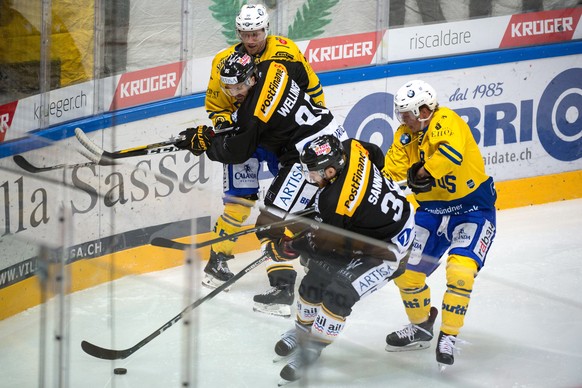 Davos&#039;s Enzo Corvi, Lugano’s Raffaele Sannitz, Lugano&#039;s Thomas Wellinger and Davos&#039;s Gregory Sciaroni, from left, fight for the puck, during the preliminary round game of National Leagu ...