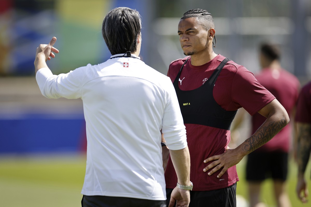 Switzerland's head coach Murat Yakin, left, talks to player Manuel Akanji during a training session at the Robert-Schlienz-Stadion in Stuttgart, Germany, Tuesday, June 18, 2024. (Peter Klaunzer/K ...