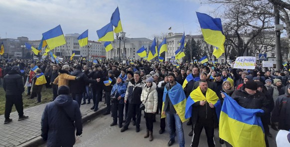 People wave Ukrainian flags during a rally against the Russian occupation in Svobody (Freedom) Square in Kherson, Ukraine, Saturday, March 5, 2022. Ever since Russian forces took the southern Ukrainia ...