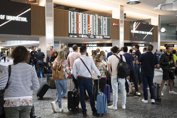 epa10013877 Passengers wait in front of a display board at Zurich airport, Switzerland, 15 June 2022. Due to an IT breakdown at Skyguide, Zurich and Geneva airports are currently out of service. The S ...