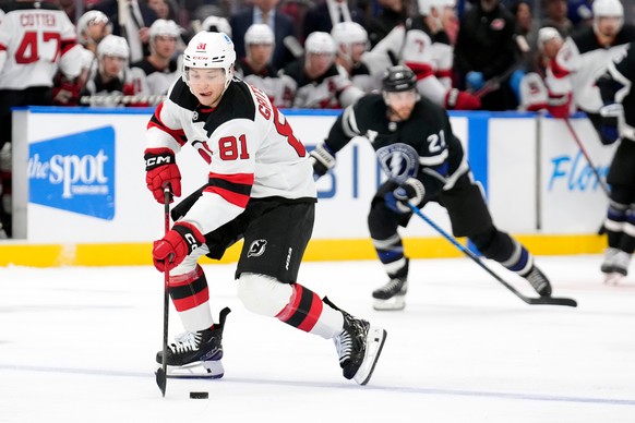 New Jersey Devils right wing Arseny Gritsyuk (81) breaks out ahead of Tampa Bay Lightning center Brayden Point (21) during the third period of an NHL hockey game Saturday, Oct. 11, 2025, in Tampa, Fla ...