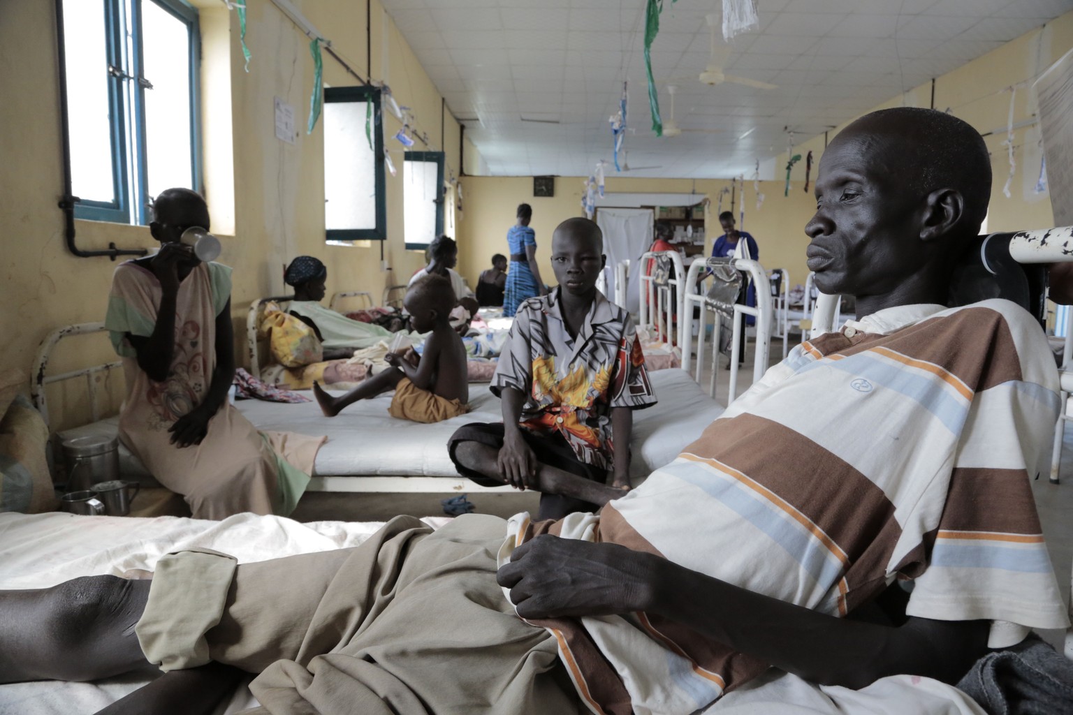 In this photo taken Saturday, July 8, 2015, Akuel, 48, who was bitten twice in his right leg by a saw-scaled viper while working his garden and received injections of anti-venom and tetanus treatment, ...