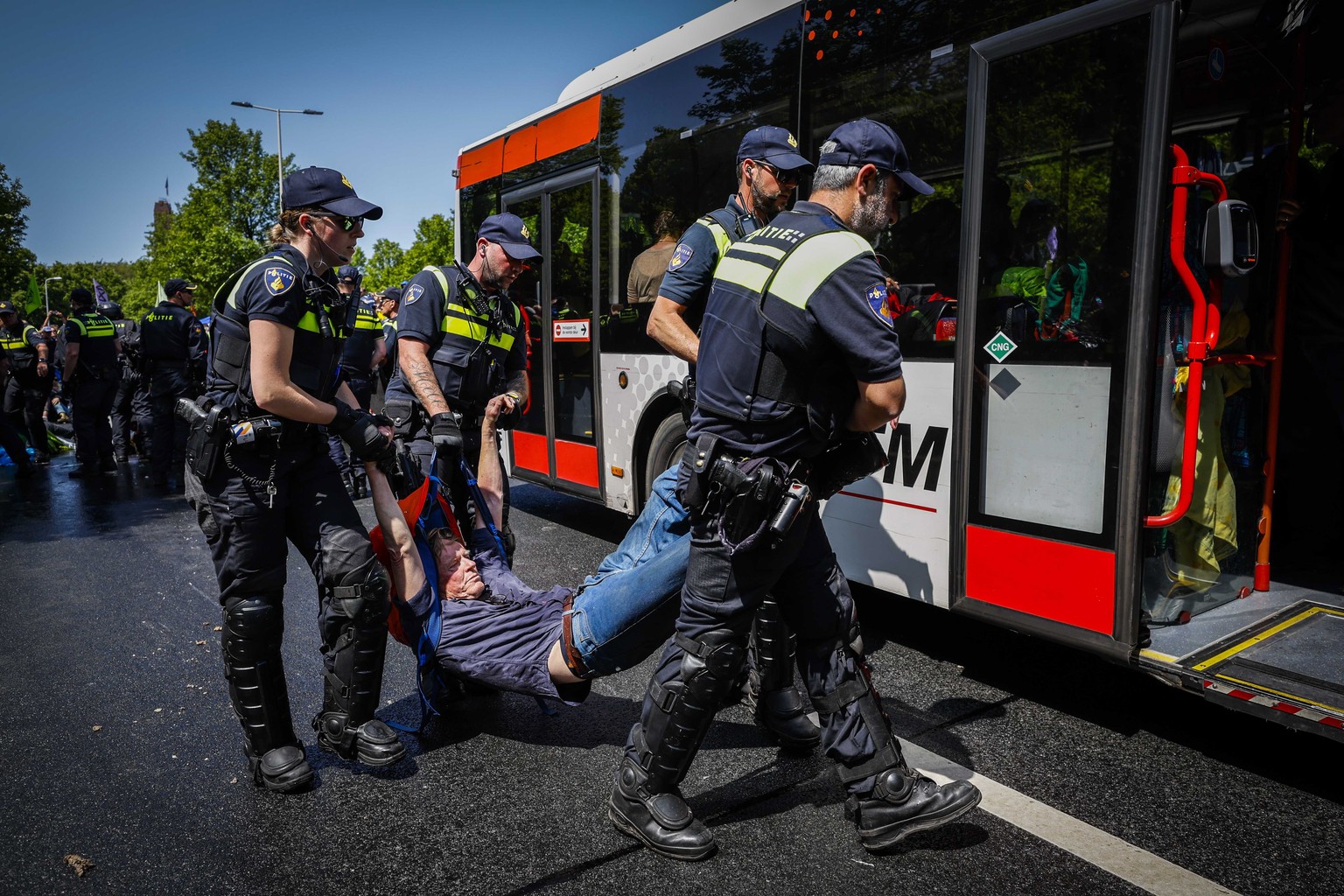 epa10657410 Police officers remove activists from Extinction Rebellion blocking the A12 in The Hague, Netherlands, 27 May 2023. With the action, Extinction Rebellion wants to make the Dutch government ...