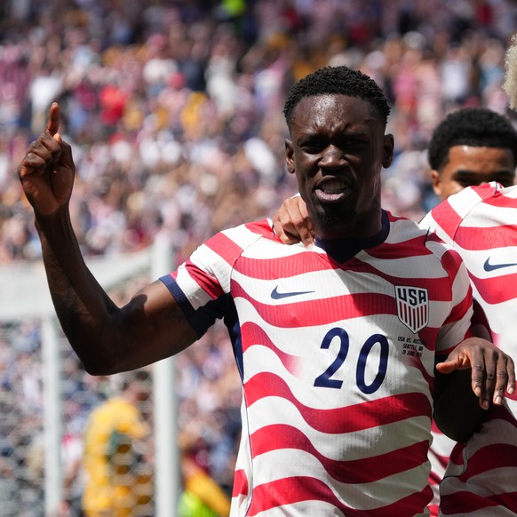 United States' Folarin Balogun (20) and Antonee Robinson (5) celebrate after Australia's Cameron Burgess scored an own goal during the World Cup Group D soccer match between the United State ...