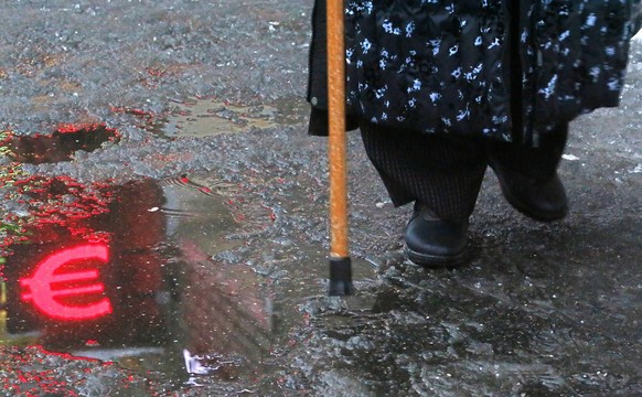 epa10376397 A woman walks in front of a currency exchange office as a Euro symbol is reflected in melted ice in Moscow, Russia, 22 December 2022. At the opening of trading on the Moscow Exchange, the  ...