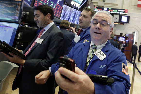 James Dresch, right, works with fellow traders on the floor of the New York Stock Exchange, Wednesday, Jan. 31, 2018. Stocks are opening solidly higher on Wall Street after a number of big U.S. compan ...