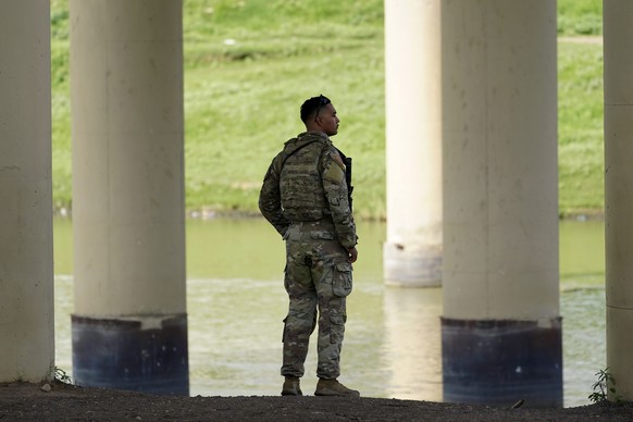FILE - A member of the Texas National Guard looks across the Rio Grande to Mexico from the U.S. at Eagle Pass, Texas, Friday, Aug. 26, 2022. Texas will build an operations base for up to 1,800 Nationa ...