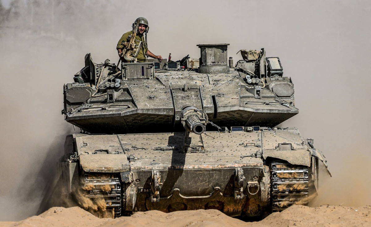 Israeli soldiers drive a tank at a staging ground near the border with the Gaza Strip, in southern Israel, Sunday, May 5, 2024. (AP Photo/Tsafrir Abayov)
