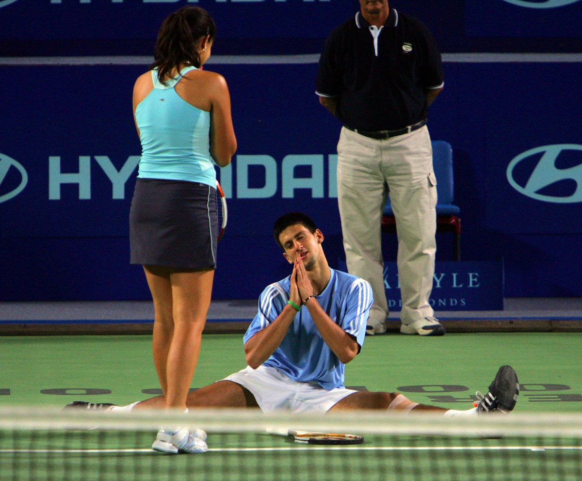 Novak Djokovic of Serbia and Montenegro clowns with teammate Ana Ivanovic on their way to defeating Sweden's Thomas Johansson and Sofia Arvidsson , 6-2, 6-4 in their doubles decider match at the  ...