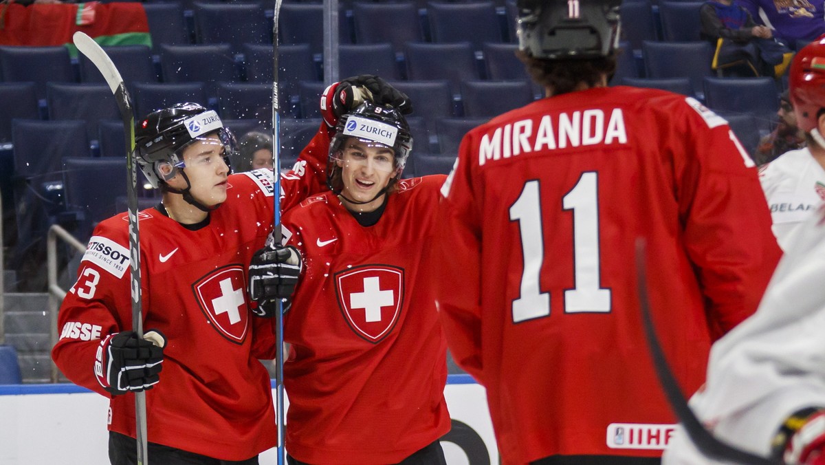 Switzerland's Nicolas Muller, center, celebrates his goal with teammates Philipp Kurashev, left, and Marco Miranda against Belarus during the first period of IIHF World Junior Championship prelim ...