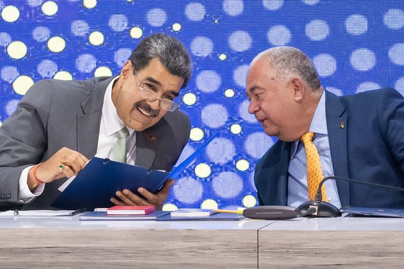 epa11011010 Venezuelan President Nicolas Maduro (L) speaks with the President of National Electoral Council (CNE) Elvis Amoroso (R), during an event about the non-binding referendum in Caracas, Venezu ...