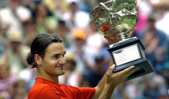 Roger Federer of Switzerland celebrates with the winners trophy after winning the 2004 Australian Open mens title Sunday 01 Febuary 2004. Federer defeated Russian Marat Safin in straight sets 7-6, 6-4 ...